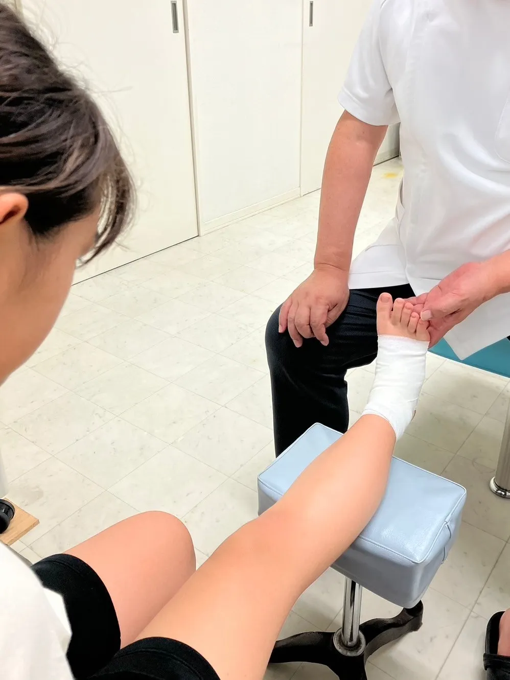 写真：子供の足に包帯を巻いています。