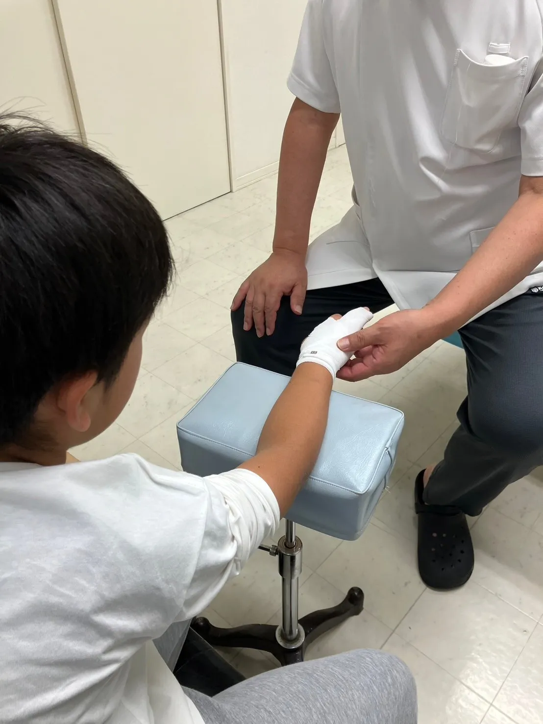 写真：子供の手に包帯を巻いています。