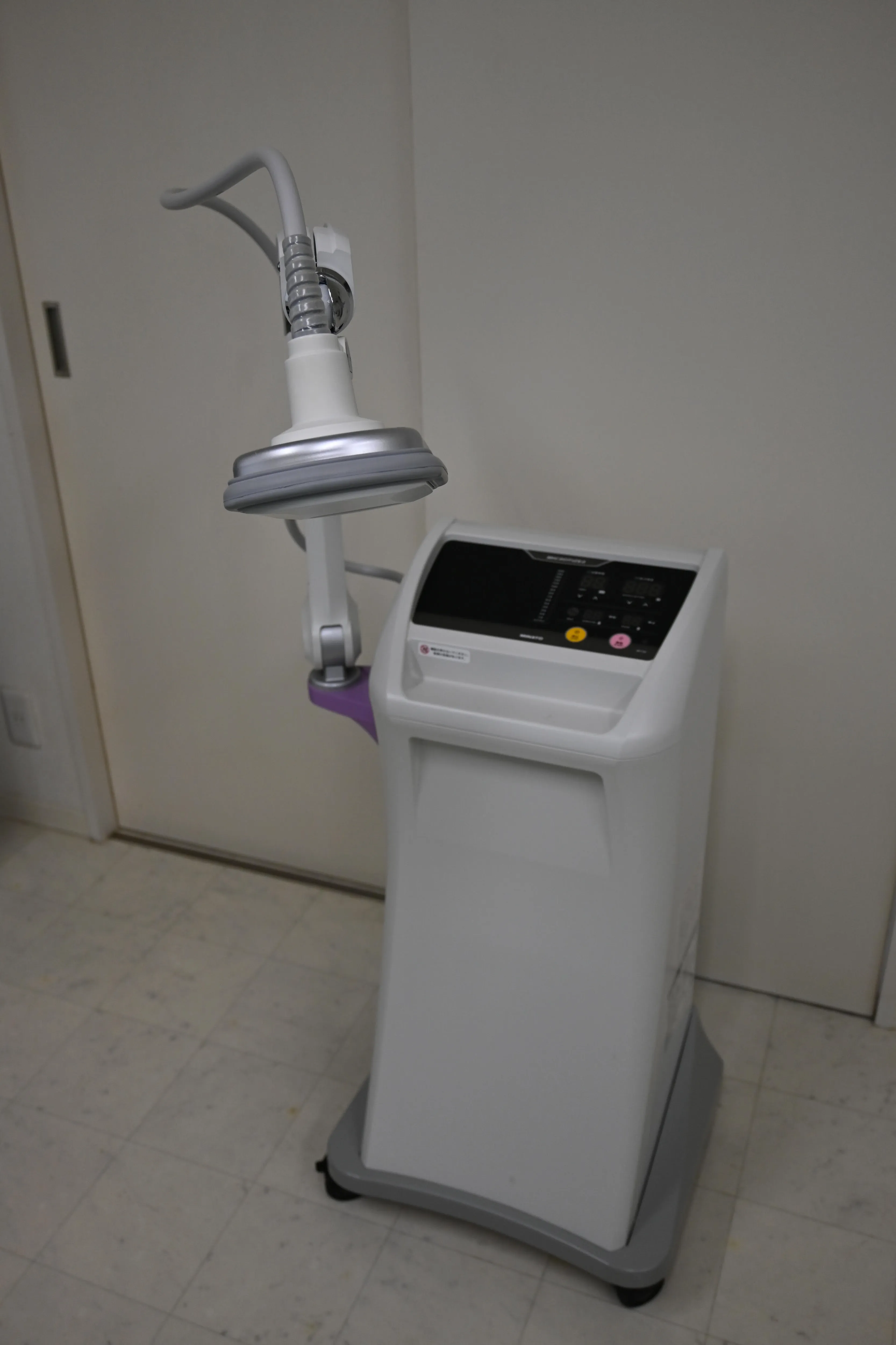 写真：機械。ベッドの合間に置いてあります。沢山のボタンととコードがついています。